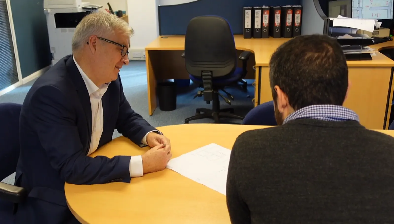 A structural engineer reviewing RAAC drawings at a desk